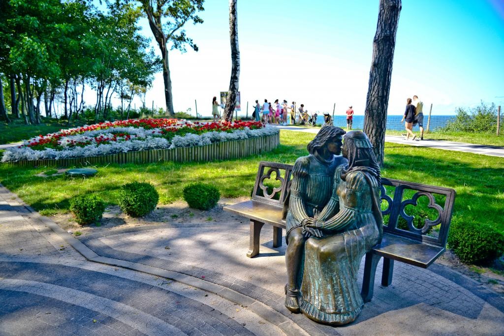 Pomnik Romea i Julii siedzacych na ławce, znajdujący sie w rewalskiej alei Zakochanych